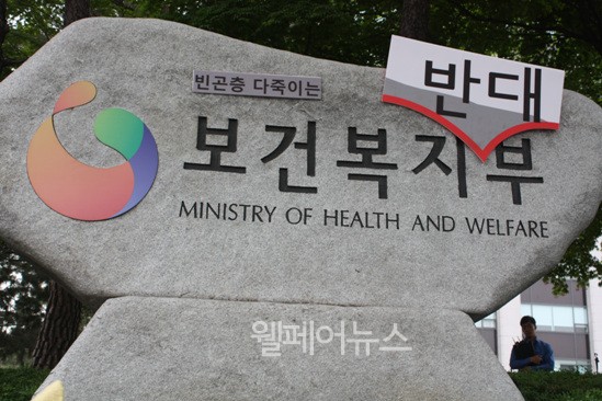 ▲ 국회 법 개정 논의 과정에서 반대 입장을 내세웠던 복지부를 규탄하기 위해 기초법개정공동행동은 복지부 간판 에 '반대'라는 푯말을 붙였다.  ⓒ정두리 기자